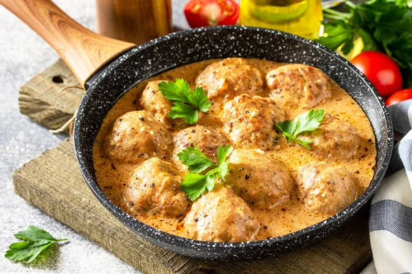 Albóndigas en crema agria y salsa de tomate en una sartén en ston —  Fotos de Stock