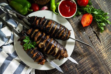 Yaz Barbeküsü menüsü. Kaba ahşap masada domuz pastırmalı ızgara patlıcan. Üst görünüm düz arkaplan. Boşluğu kopyala