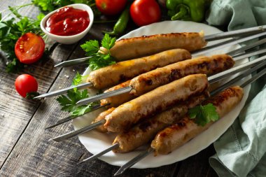 Yaz Barbeküsü menüsü. Köy ahşap masada ızgara sosis..