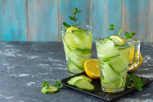 Fresh Cold and refreshing detox water with lemon and cucumber on a stone table. Copy space.