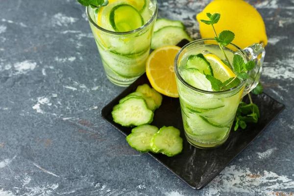 Fresh Cold and refreshing detox water with lemon and cucumber on a stone table. Copy space.