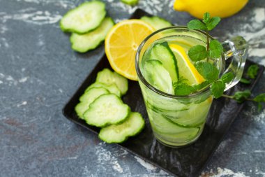 Taze soğuk ve ferahlatıcı arınma suyu. Taş bir masada limon ve salatalıkla.. 