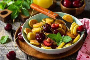 Minik krepler moda yemekler. Kirazlı mini krep ve ahşap bir masada bal..