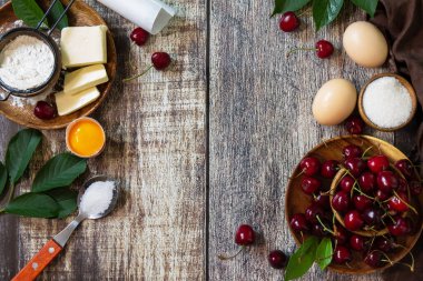 Fırın mevsimi kavramı. Kırsal bir ahşap masada kirazlı turta (kırmızı kiraz, un, yumurta, şeker ve tereyağı) için malzemeler. Düz bir yatağın üst görüntüsü. Boşluğu kopyala.