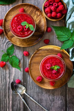 Ahudududulu panna cotta, ahududu reçelli İtalyan tatlısı, ev yapımı mutfak. Üst görünüm düz arkaplan.