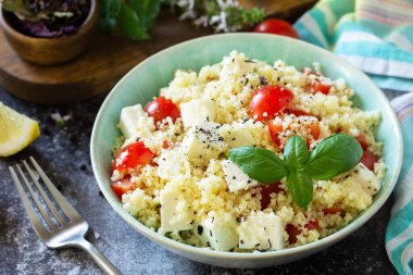 Doğu mutfağı. Kuskus, domates, feta peyniri, fesleğen, biber ve zeytinyağlı sağlıklı salata..