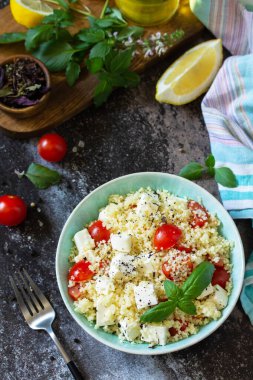 Doğu mutfağı. Kuskus, domates, feta peyniri, fesleğen, biber ve zeytinyağlı sağlıklı salata..
