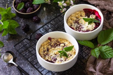 Ev yapımı yaz tatlısı. Böğürtlen kırıntıları taş bir tezgahın üzerinde. 