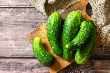 Taze sebze. Ahşap masada çirkin organik salatalıklar. En üstteki düz yerde. Boşluğu kopyala.