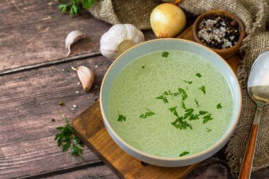 Sıcak, zengin et suyu (bouillon) ve kırsal bir masada otlar. Boşluğu kopyala.