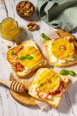 Sağlıklı kahvaltı, atıştırmalık, atıştırmalık. Mutfak masasında karamelize edilmiş ananas, pastırma, fındık ve ricotta..