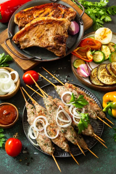 自家製のコフタケバブ 焼きステーキ 野菜とソースを石やスレートの背景に串焼き野菜 — ストック写真