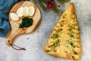 Noel atıştırması. Mozarellalı pizza ve gri masa arkasında ıspanak. Üst görünüm düz arkaplan.