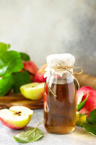 Apple vinegar. Healthy organic food. A bottle of apple cider vinegar on a light stone countertop. Copy space.