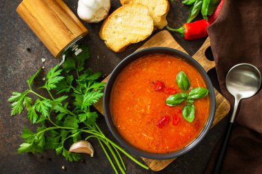 Vejetaryen sağlıklı yemek. Koyu bir taş üzerinde domates çorbası ya da gazpacho. Düz üst görünüm.