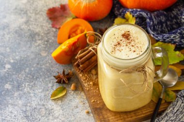 Sonbahar balkabağı aromalı latte ya da bardakta kahve ve hafif taş tezgahta organik malzemeler. Boşluğu kopyala. 