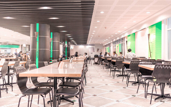 Modern interior of cafeteria or canteen with chairs and tables, eating room in selective focus