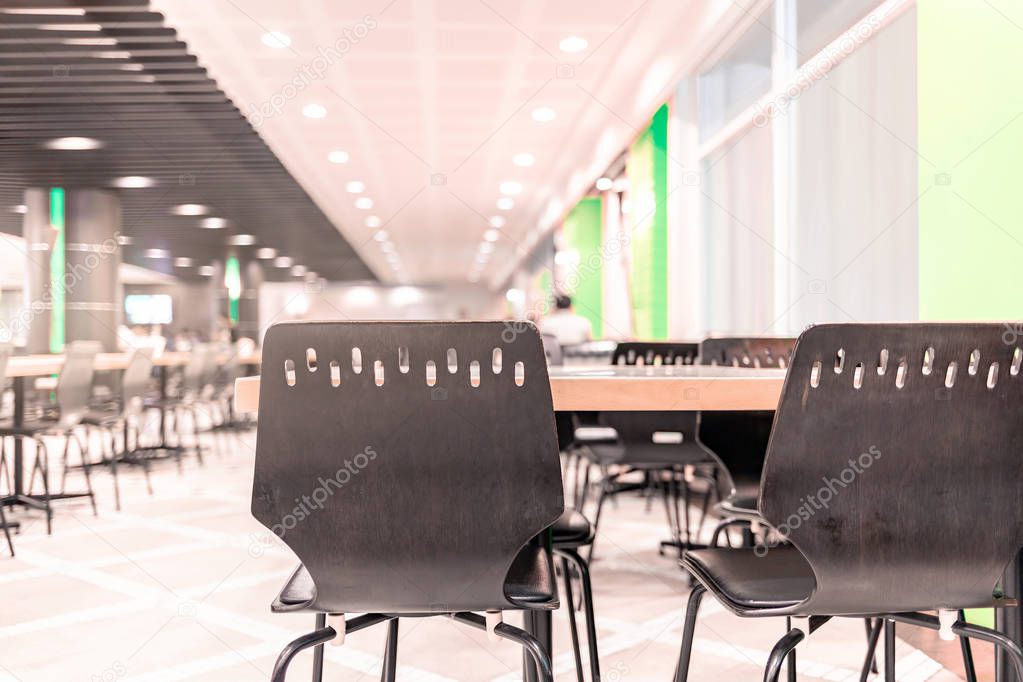 Modern interior of cafeteria or canteen with chairs and tables, eating room in selective focus