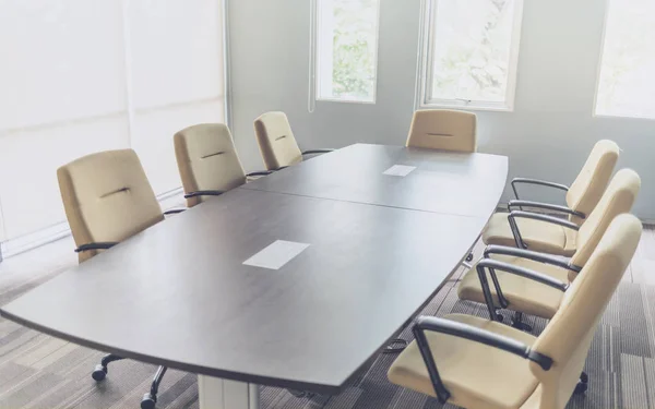 modern interior of meeting or seminar room with office chair and wooden table at workplace in selective focus