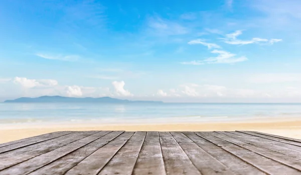 wooden table top or wooden plank in front of the beach background for products or object display