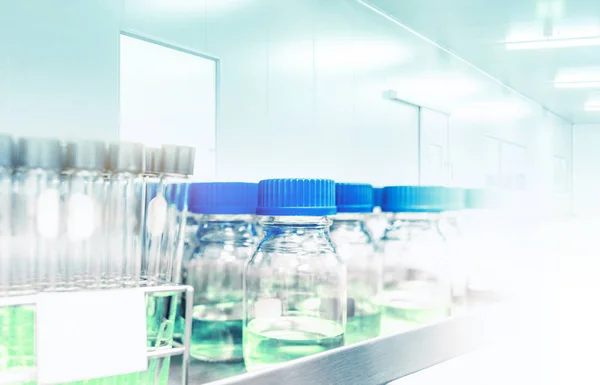 science nutritional laboratory testing glass tubes and bottles with blue liquid in selective focus, science lab concept background