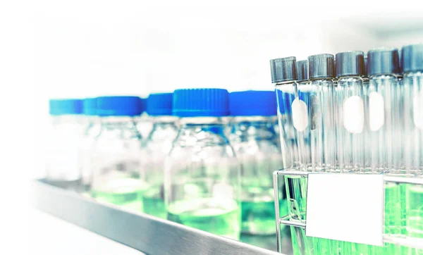 science nutritional laboratory testing glass tubes and bottles with blue liquid in selective focus, science lab concept background