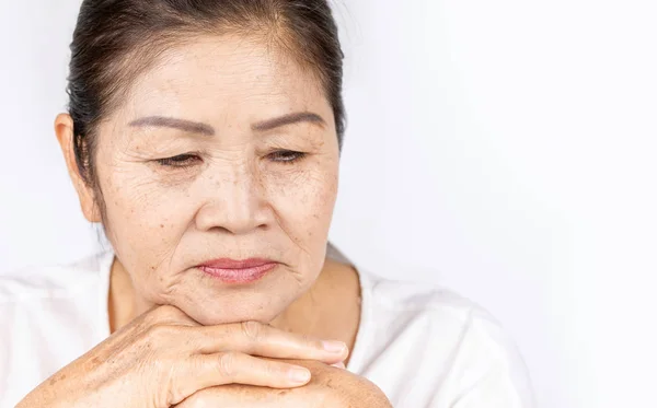 Old wrinkled asian woman thinking with copy space — Stock Photo, Image