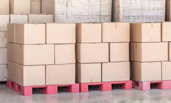 Pila de cajas de cartón de mercancías en paleta roja en almacén logístico — Foto de Stock