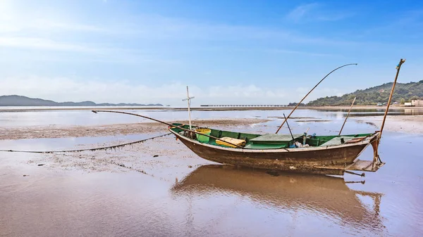 Рыбацкая лодка причаливает на песчаных прутьях на рассвете — стоковое фото