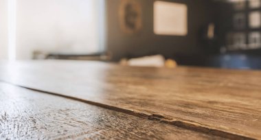 Montaj ürünü görüntüsü veya tasarım anahtarı görsel düzeni için pencereden seçici odaklanma ve güneş ışığına sahip tahta masa üstü