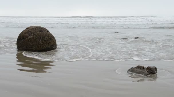 Rochers Moeraki dans les vagues de l'océan Pacifique — Video