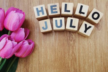 Merhaba Temmuz ile ahşap arka plan üzerinde yapay çiçek