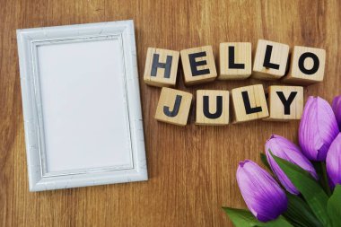 Merhaba Uzay fotoğraf çerçeve ve çiçek buketi alfabe harfler ahşap arka plan üzerinde Temmuz