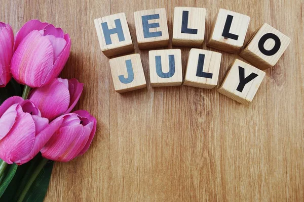 Merhaba Temmuz ile ahşap arka plan üzerinde yapay çiçek