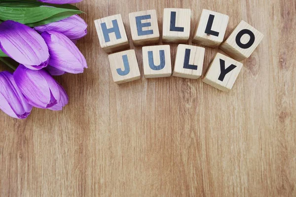 Merhaba Temmuz ile ahşap arka plan üzerinde yapay çiçek