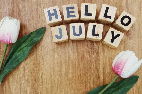 Merhaba Temmuz ile ahşap arka plan üzerinde yapay çiçek