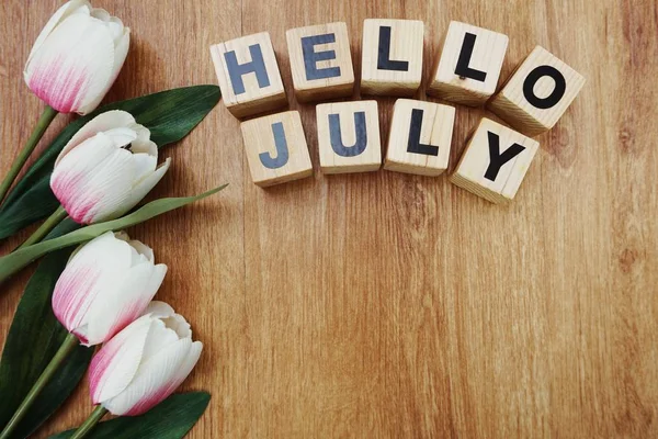 Merhaba Temmuz ile ahşap arka plan üzerinde yapay çiçek