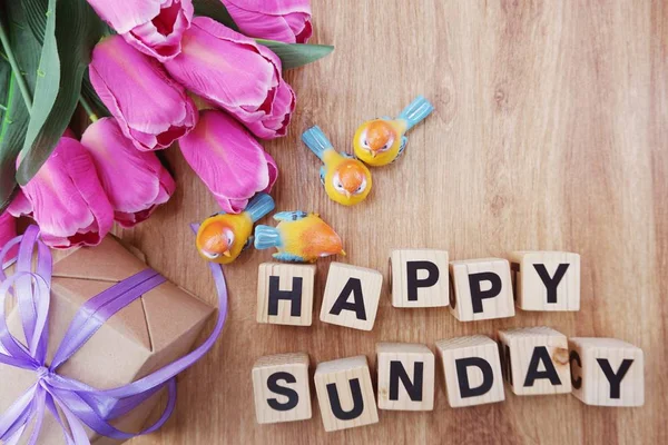 mutlu Pazar aphabet harfleri ve lale yapay çiçekler Buket ahşap arka plan üzerinde