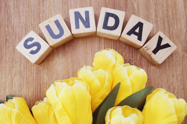 Pazar alfabesi harfleri üstten görünüm yapay çiçek buketi ile ahşap arka plan üzerinde