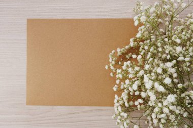 Kağıt el sanatları ve ahşap arka plan üzerinde kuru çiçekler