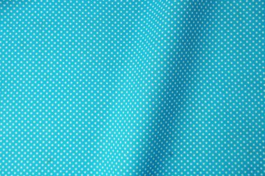 Beyaz puantiyeli desenli mavi kumaş yakın çekim