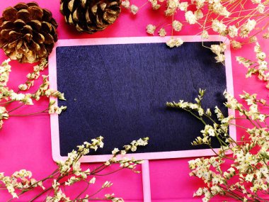 alan siyah kurulu ve ahşap arka plan üzerinde kuru çiçek üstten görünüm