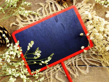 alan siyah kurulu ve ahşap arka plan üzerinde kuru çiçek üstten görünüm