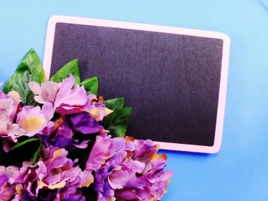 mavi arka plan üzerinde siyah alan Yönetim Kurulu ve çiçek üstten görünüm