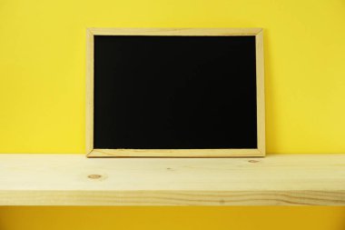 boş yazı tahtası sarı arka plan düz üzerinde yatıyordu