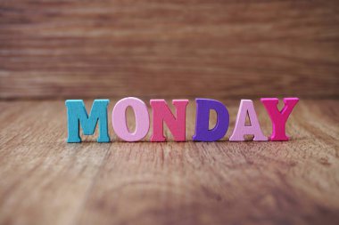 ahşap arka plan üzerinde renkli Pazartesi alfabesi harfleri