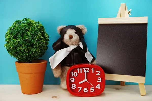 teddy bear and alarm clock with space copy on wooden background
