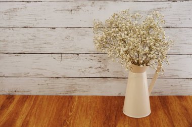 ahşap arka plan üzerinde metal vazoda çiçek buketi kurutulmuş