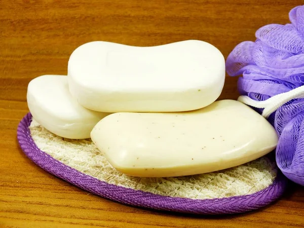 白色肥皂和塑料浴粉扑在木质背景 — 图库照片