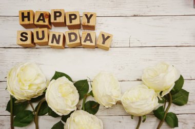 Mutlu Pazar kelime ışık kutusu ahşap arka plan üzerinde çiçek buketi ile